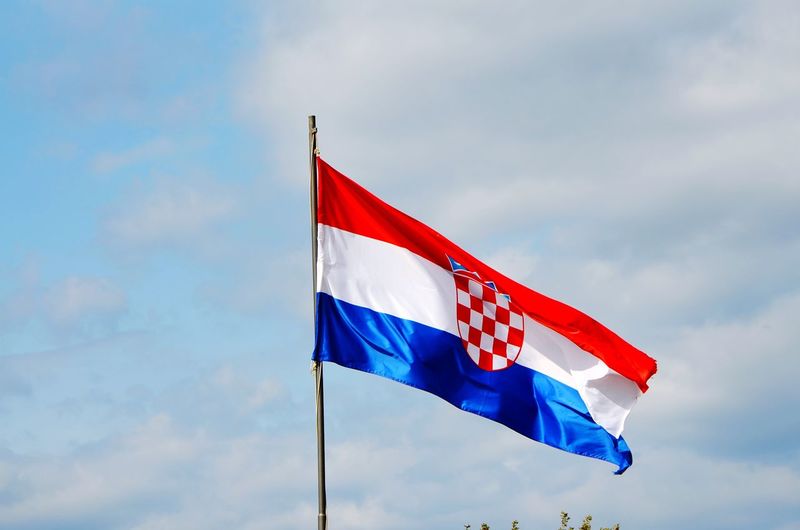 Low angle view of croatian flag waving against sky