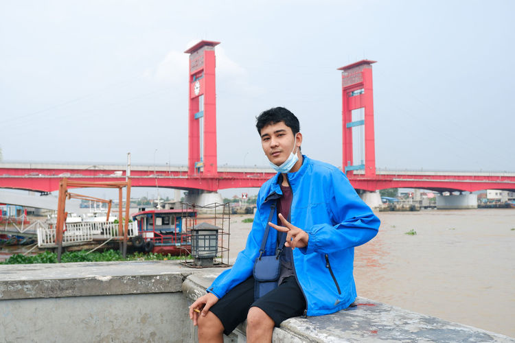 Relax on the banks of the musi river with the background of the palembang city icon ampera bridge