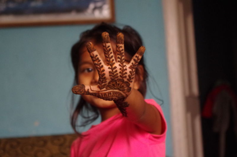 Young girl showing henna painted on hand