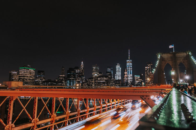 Illuminated bridge in city against sky at night