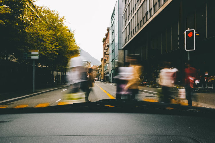 Blurred motion of people walking on road in city