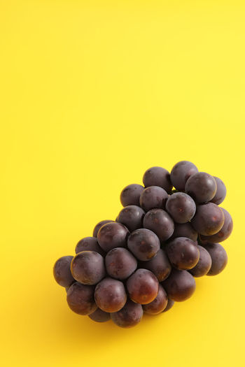 Close-up of grapes against yellow background