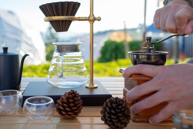 Cropped hand of woman holding coffee on table