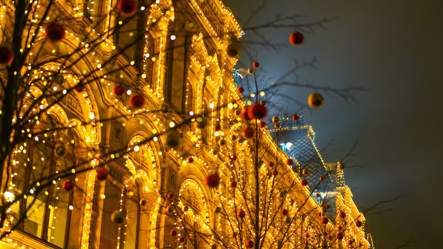 Low angle view of illuminated christmas lights in city at night