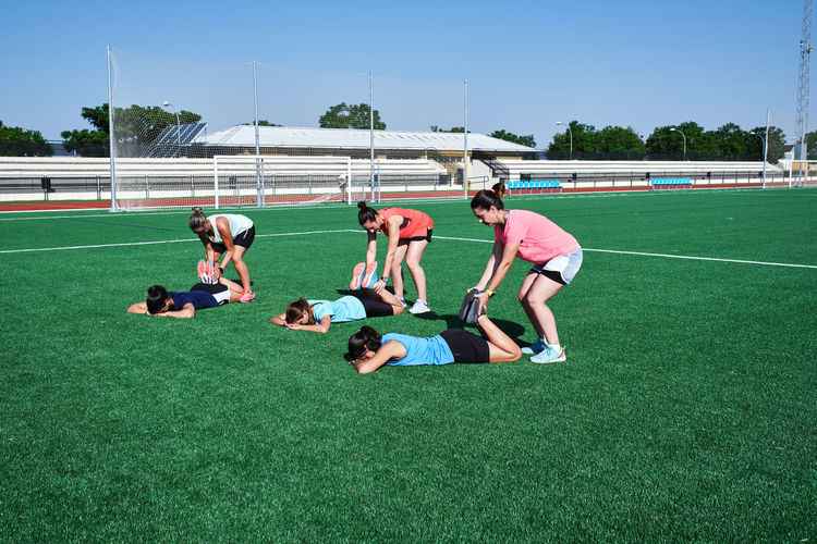Several young women practice stretching after training