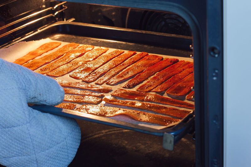Sliced carrots in the oven on a protvin for cooking carrot bacon. vegetarian food, meat replacement