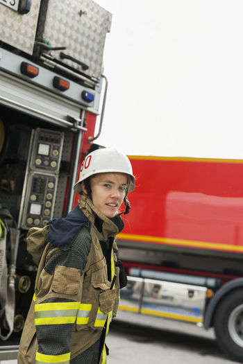 Female firefighter by fire engine