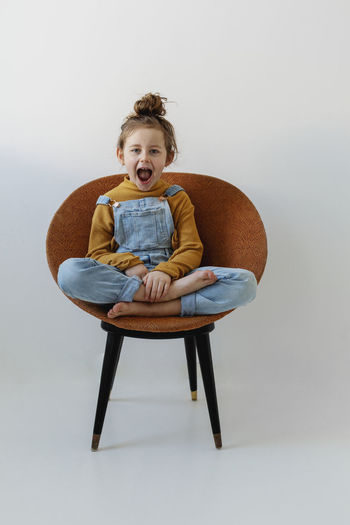 Portrait of girl sitting on chair