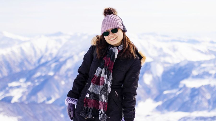 Woman standing against mountain range during winter