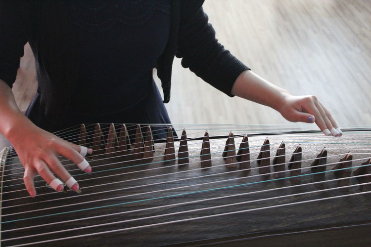 Woman playing guzheng indoors