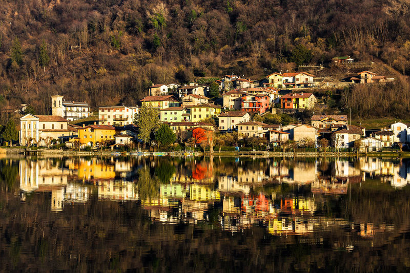 Townscape reflections by lake in city, brescia italy 
