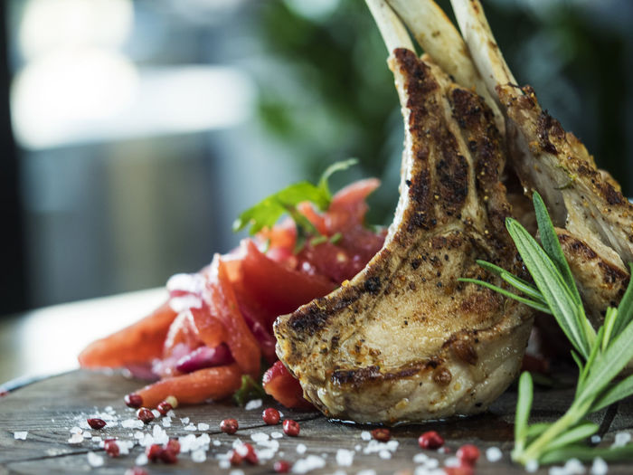 Close-up of lamb chop with rosemary on cutting board