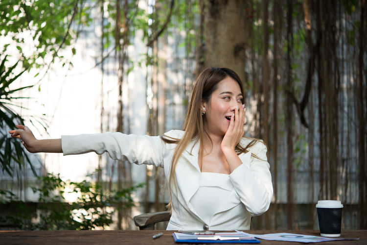 Businesswoman stretching and yawning while sitting at table