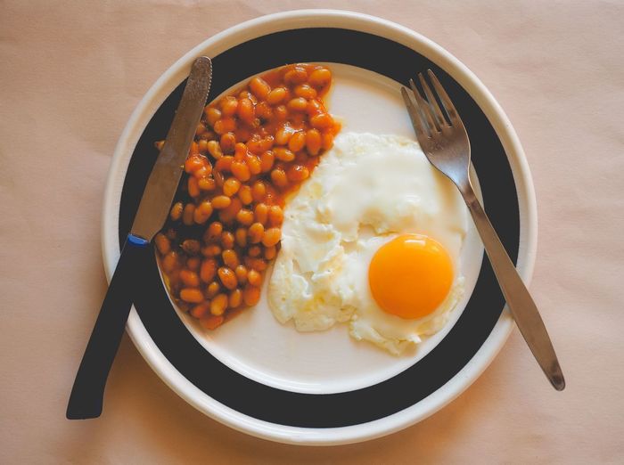 Close-up of baked beans with fried egg