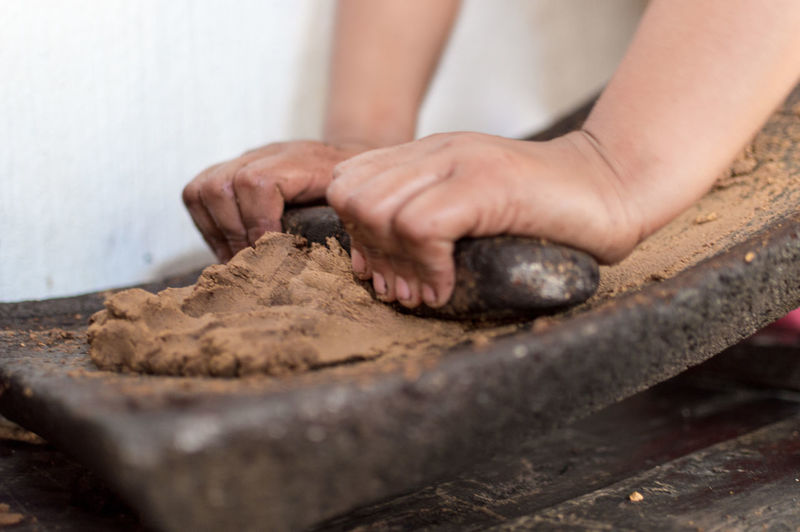 Close-up of chef crushing cocoa on mortar