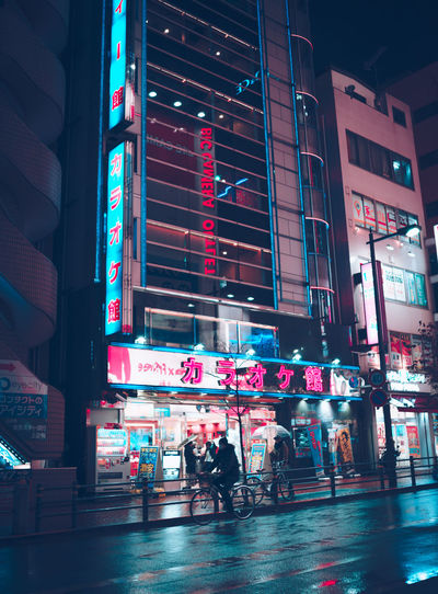 People on illuminated building at night