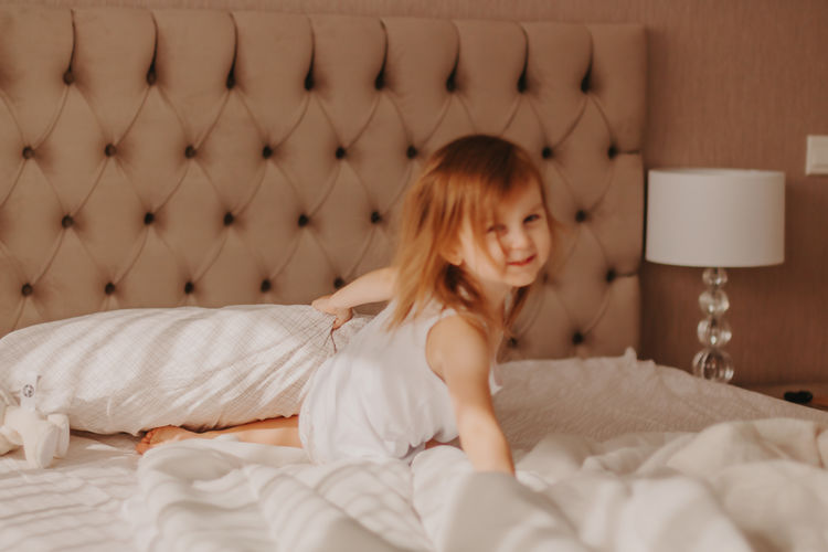 Portrait of young woman sitting on bed