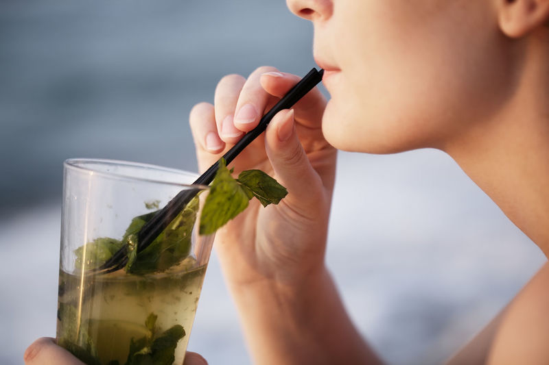 Cropped image of woman drinking mojito