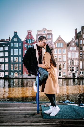 Couple kissing against buildings in city, amsterdam city trip 