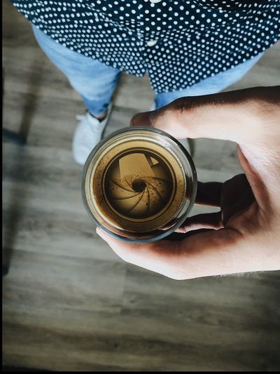 High angle view of hand holding coffee cup