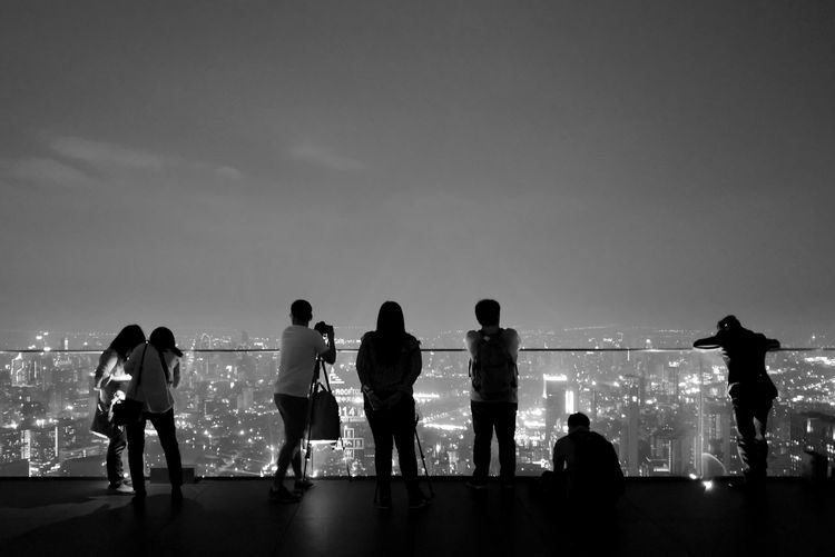 Rear view of silhouette people standing against sky