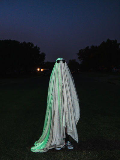 Ghost standing in the street under neon lights 