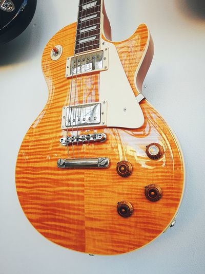 High angle view of guitar against orange background