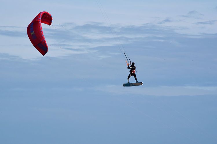 Low angle view of man kiteboarding against sky