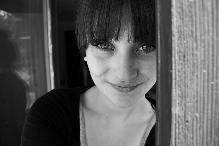 Black and white portrait of young woman with bangs smiling