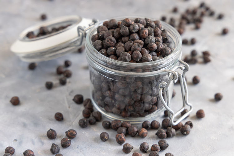 Dry black chickpea from apulia and basilicata in italy in the glass jar on grey marble table 
