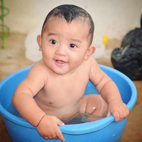 Portrait of cute baby boy in water
