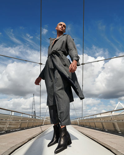 Full length of man standing by railing against sky