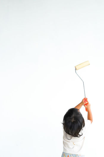 High angle view of girl holding toy against white background