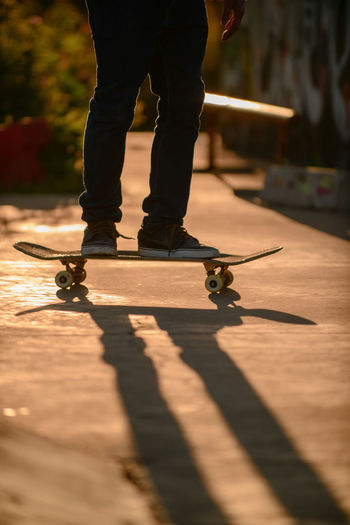 Low section of man skateboarding on footpath