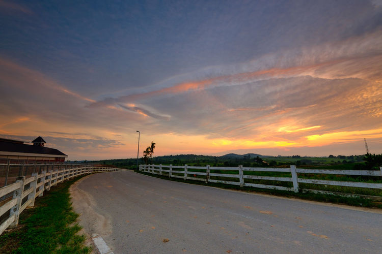 Road by bridge against sky during sunset