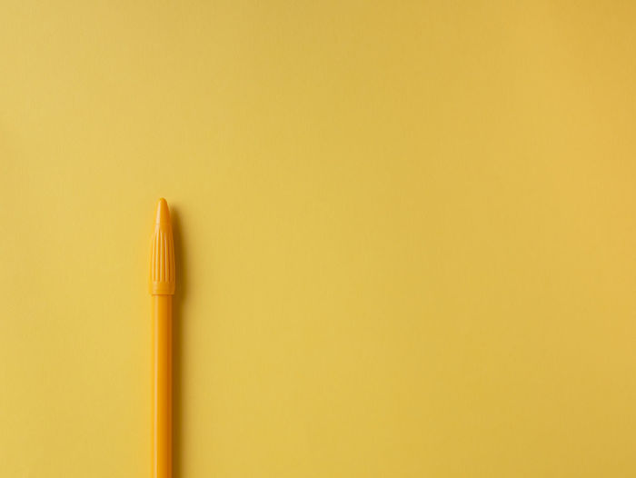 Close-up of pencils against yellow background