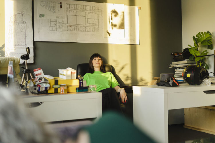Woman leaning back in architect's office