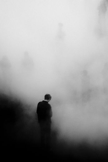 Rear view of silhouette person walking on foggy weather
