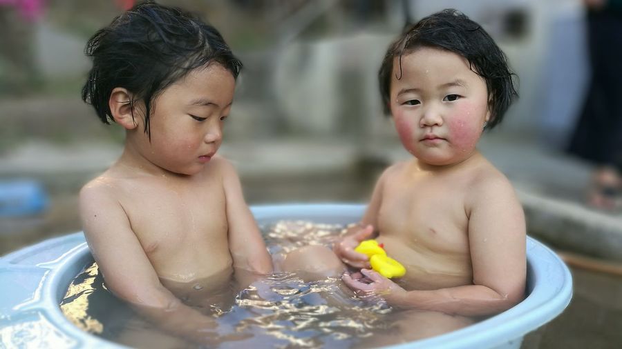 Close-up of two children taking a bath