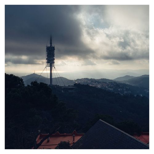 Communications tower and buildings against sky