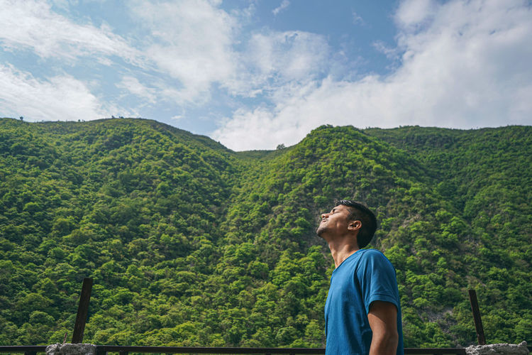 Young indian boy enjoying the view of green mountains.
