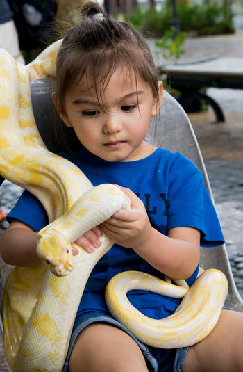 Cute girl holding albino boa constrictor