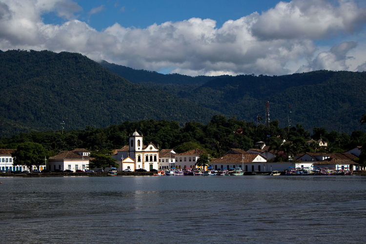 Scenic view of sea by santa rita church against mountains and sky