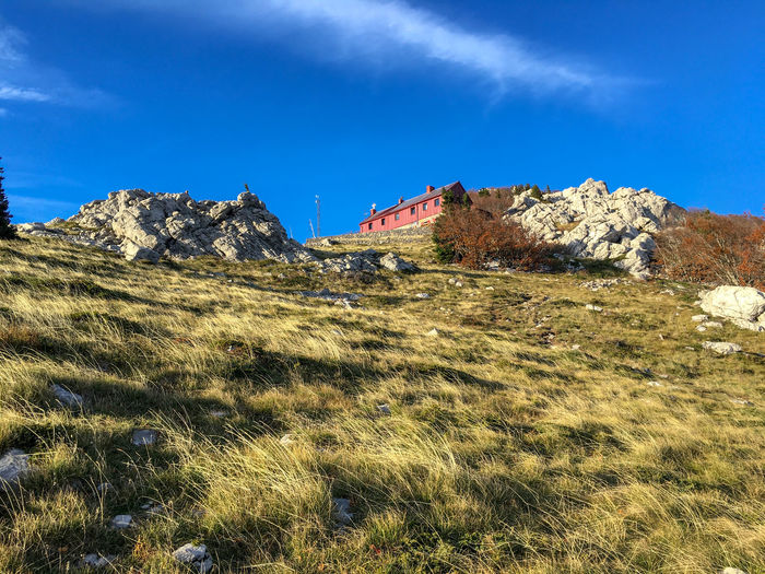 Hut in the mountain against blue sky in velebit, autumn time in croatia, bottom view