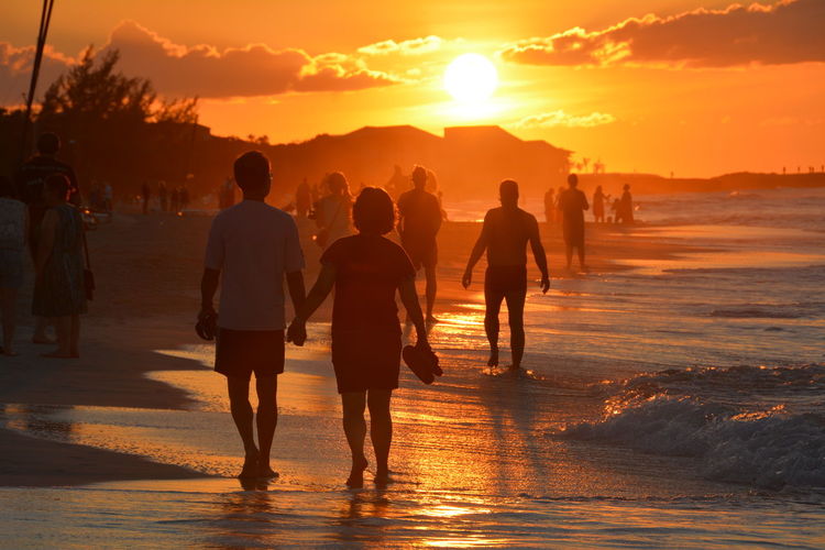 Tourists on beach at sunset