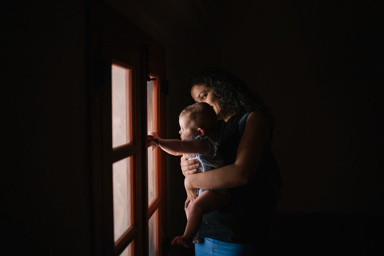 Mother with son looking through window