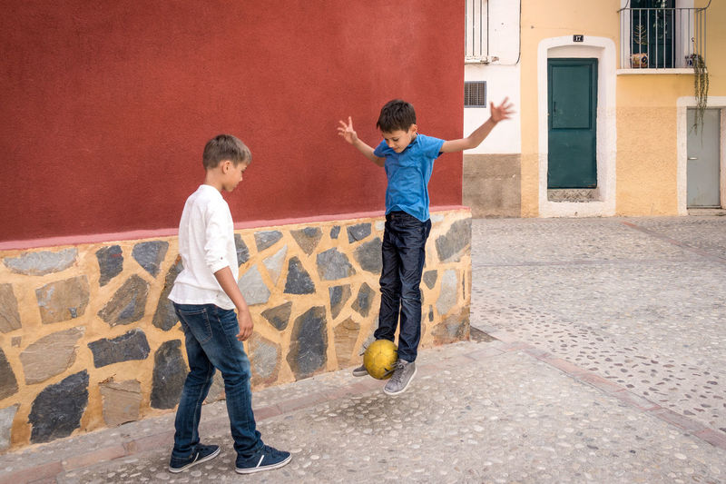 Friends playing with ball in alley