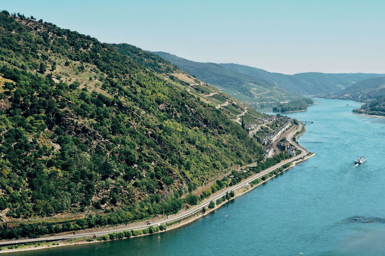 Aerial view of lake by road and hill