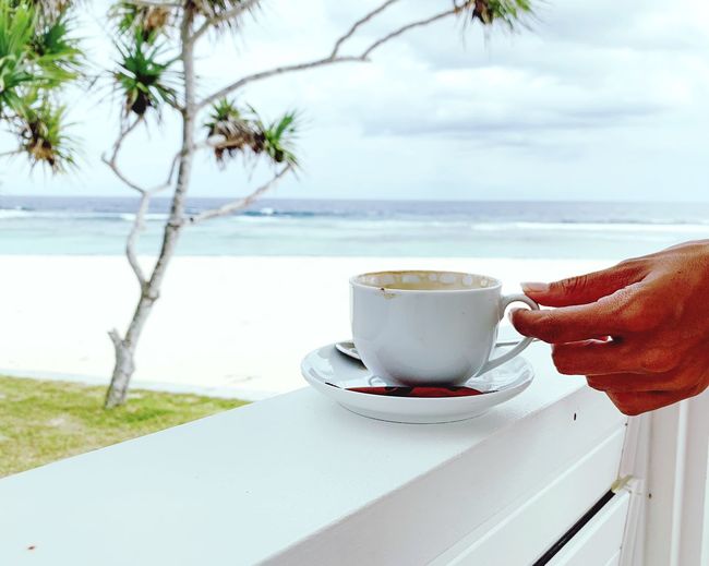 Coffee cup on table by sea