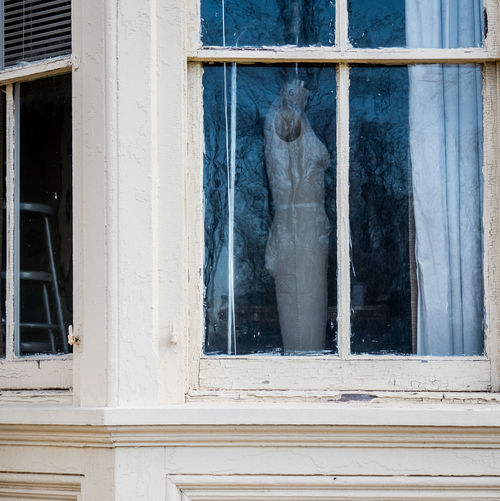 Dressmaker model seen through glass window